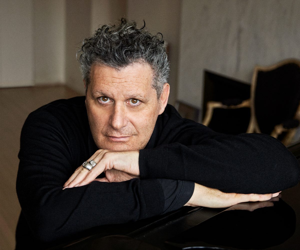 Isaac Mizrahi seated at the piano in his Manhattan apartment