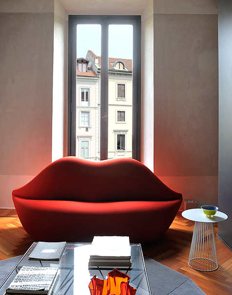 Studio 65's lip-shaped Bocca loveseat appears in a Milan apartment designed by Giuliano Dell' Uva.