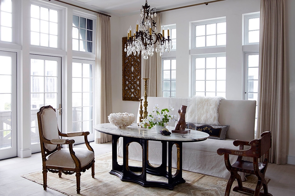 Sitting and dining area with antiques in Alys Beach Florida by Texas architect Michael Imber