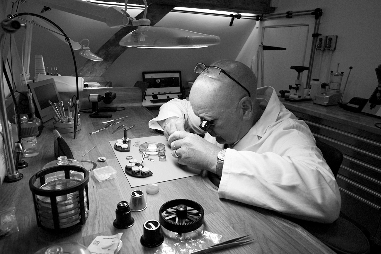 Xupes' head watchmaker Graham Forster services a timepiece in their workshop
