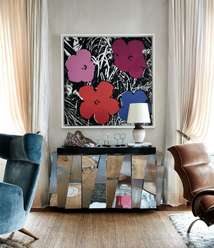 Andy Warhol flower painting hangs above a Paul Evans cabinet in the living room of a Manhattan duplex by Robert Stilin