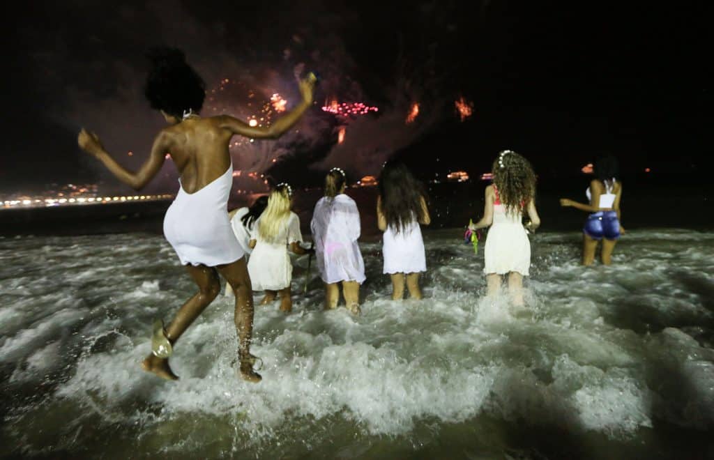 Revelers jumping waves in Brazil at midnight, a New Year's tradition meant to bring good luck in the year ahead.