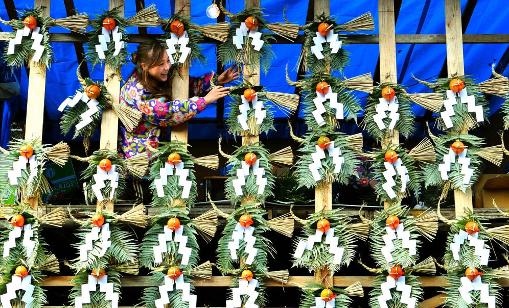 A vendor selling shimekazari New Year's ornaments, which are meant to bring good fortune, outside the Kiyoshikojin Seichoji Temple in Takarazuka, Japan.