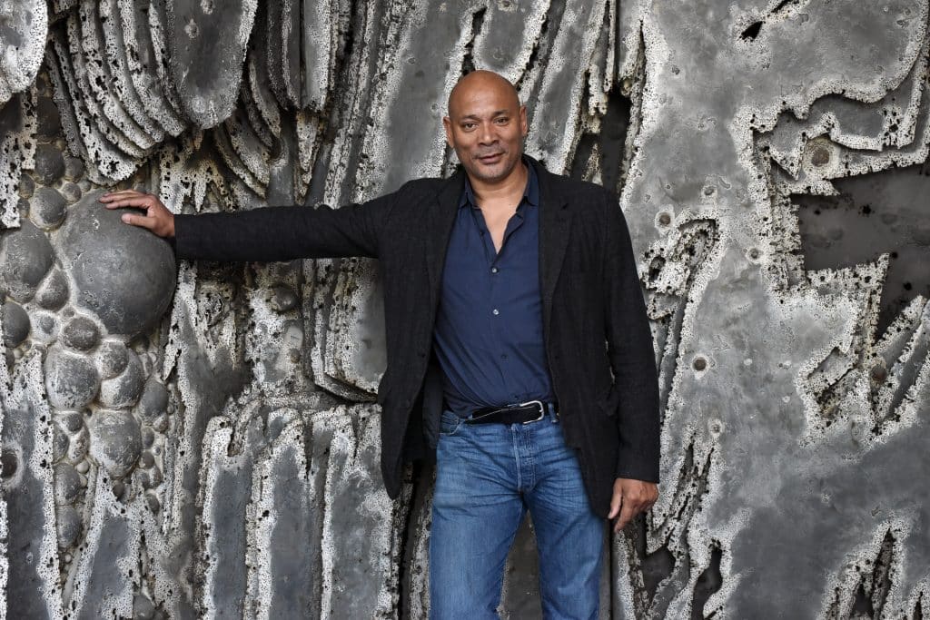 Hugues Magen, owner of Magen H Gallery, poses with a large-scale work by artist Pierre Sabatier 