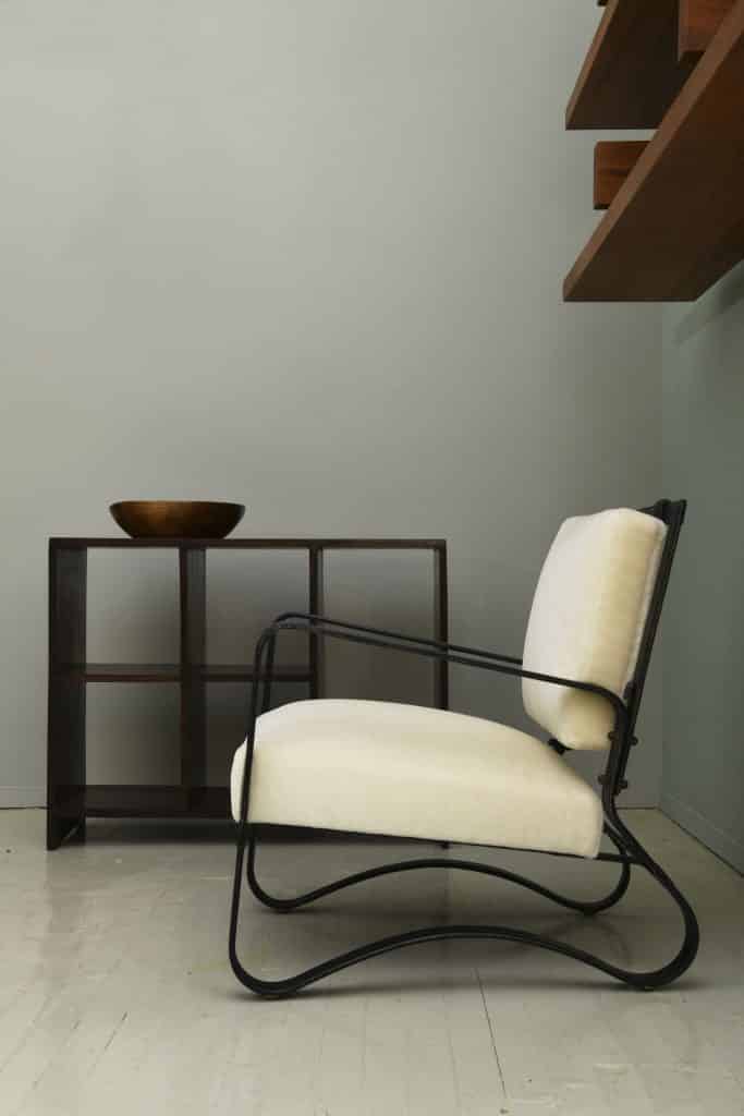 A Jacques Adnet leather chair sits next to a Pierre Jeanneret shelf at Magen H Gallery