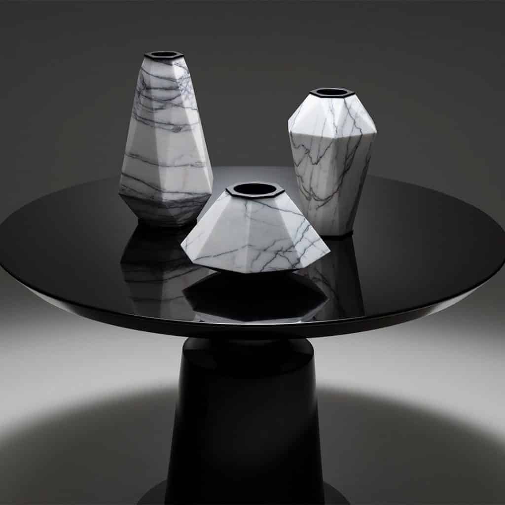 Large, medium and small marble and steel Warrior vases, created for Holly Hunt by jewelry designer Eva Fehren, resting on the Holly Hunt Peso side table