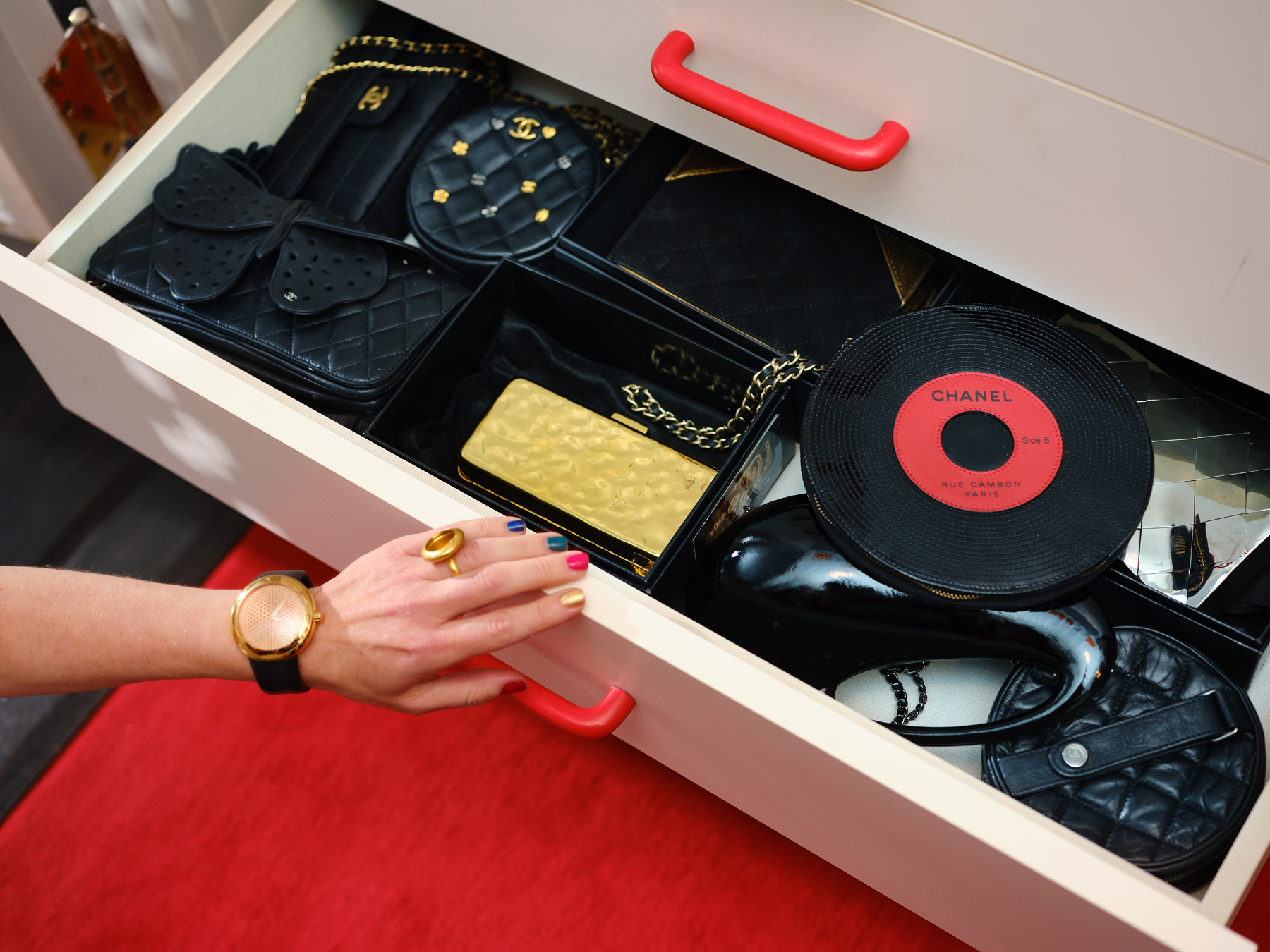 Chanel collector Sharon Coplan Hurwitz opens a drawer in her walk-in closet to reveal a few of her prized Chanel handbags