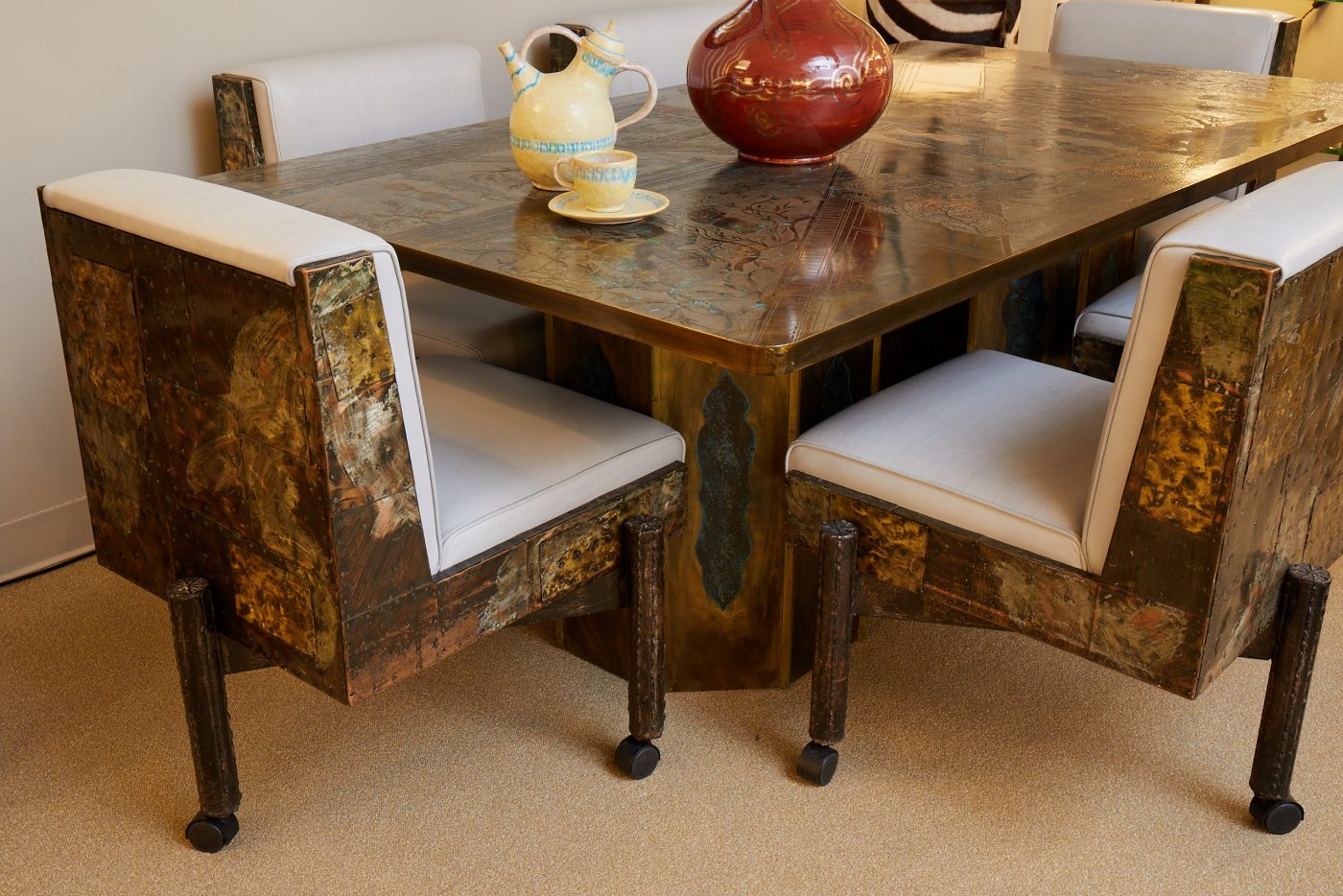 Pieces from a Guido Gambone ceramic on top of a Philip and Kelvin LaVerne dining table and Paul Evans dining chairs