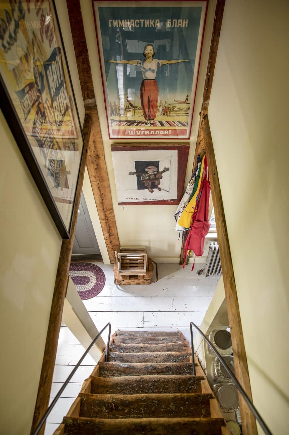 A stairway in a Maine home decorated with posters on the wall