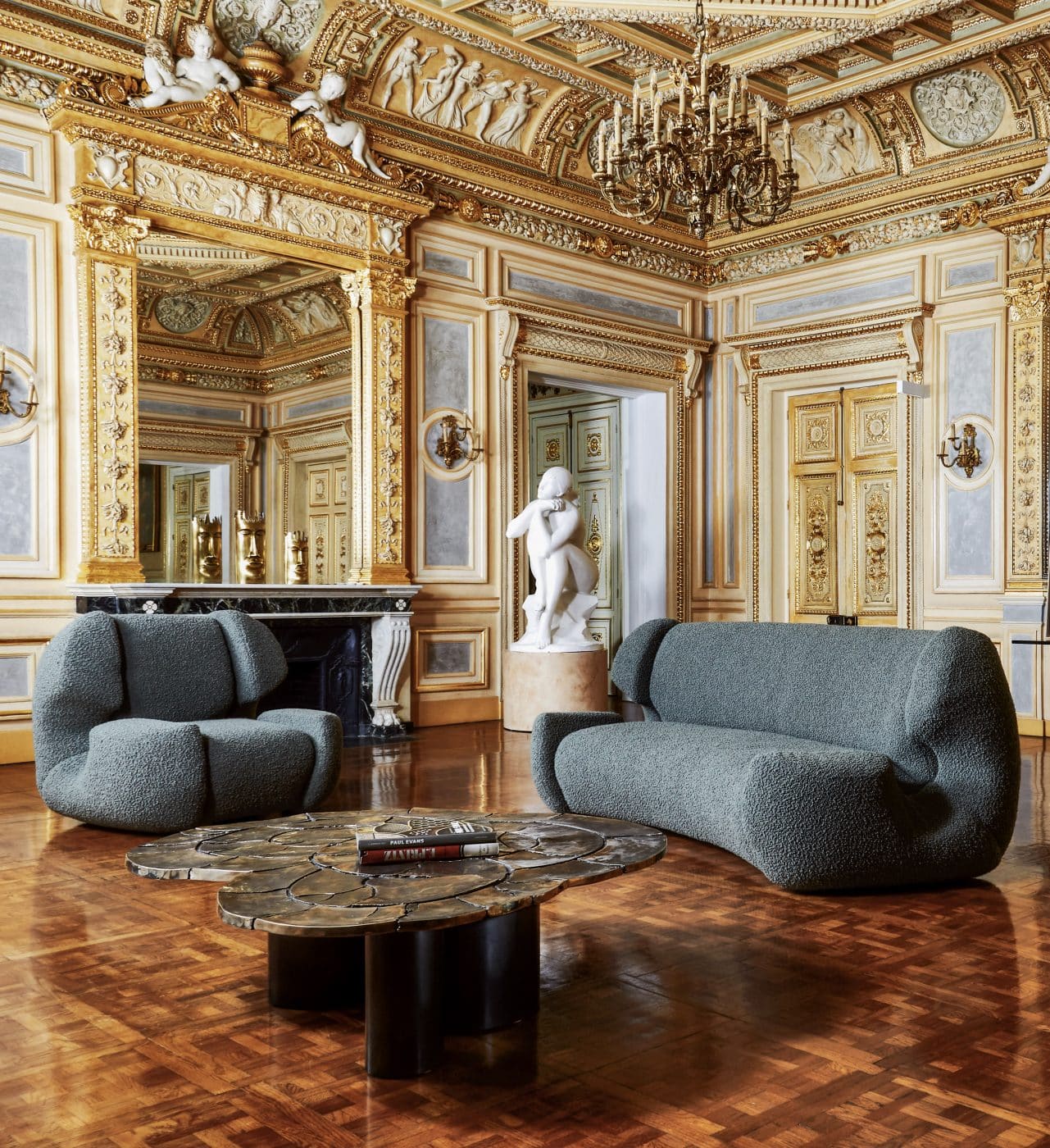 The modern forms of Studio Glustin's Colisée chair and sofa ground the ornate decor at the Palais Vivienne, a Paris exhibition space. 