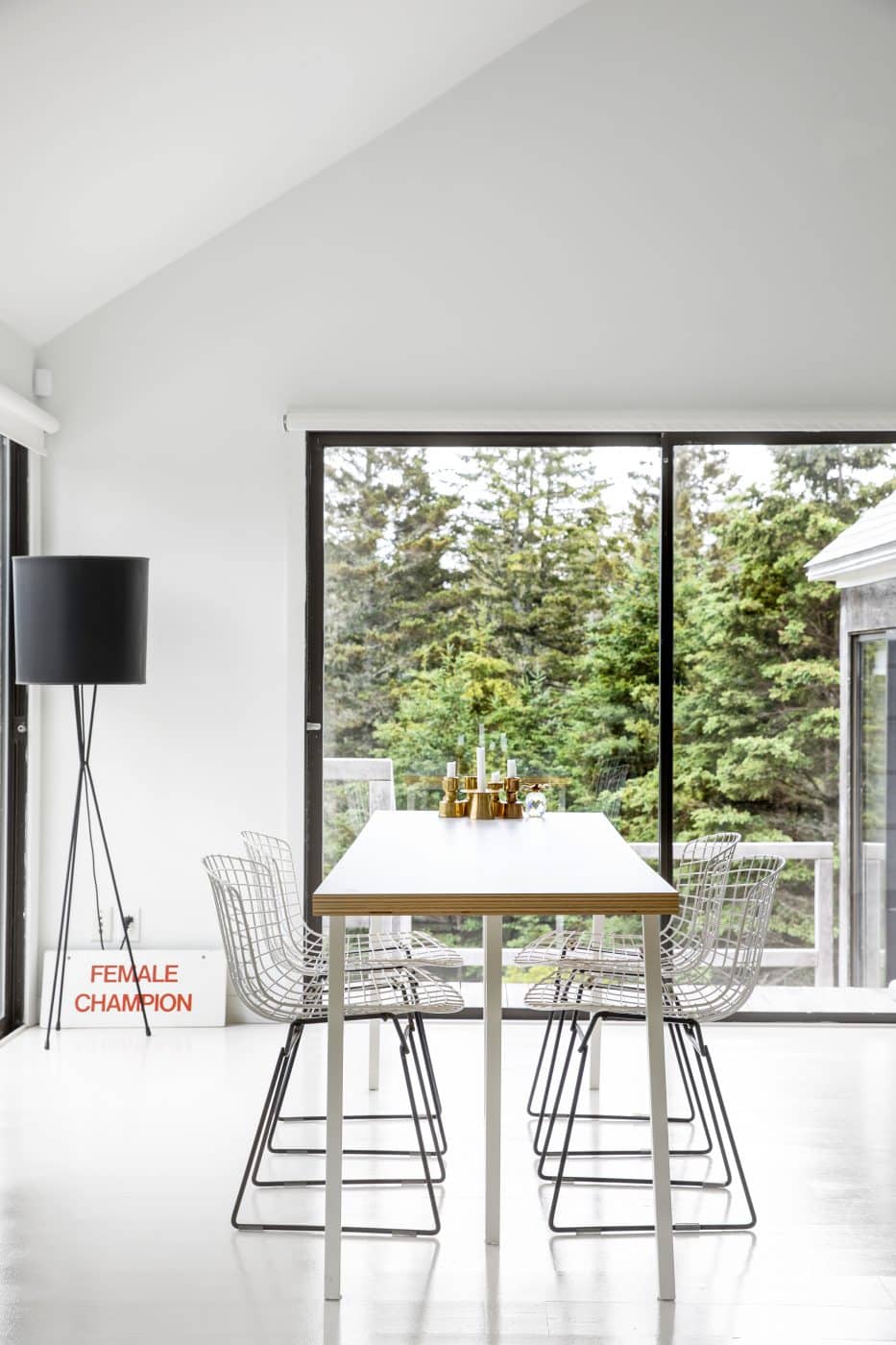 A modernist dining table surrounded by large windows