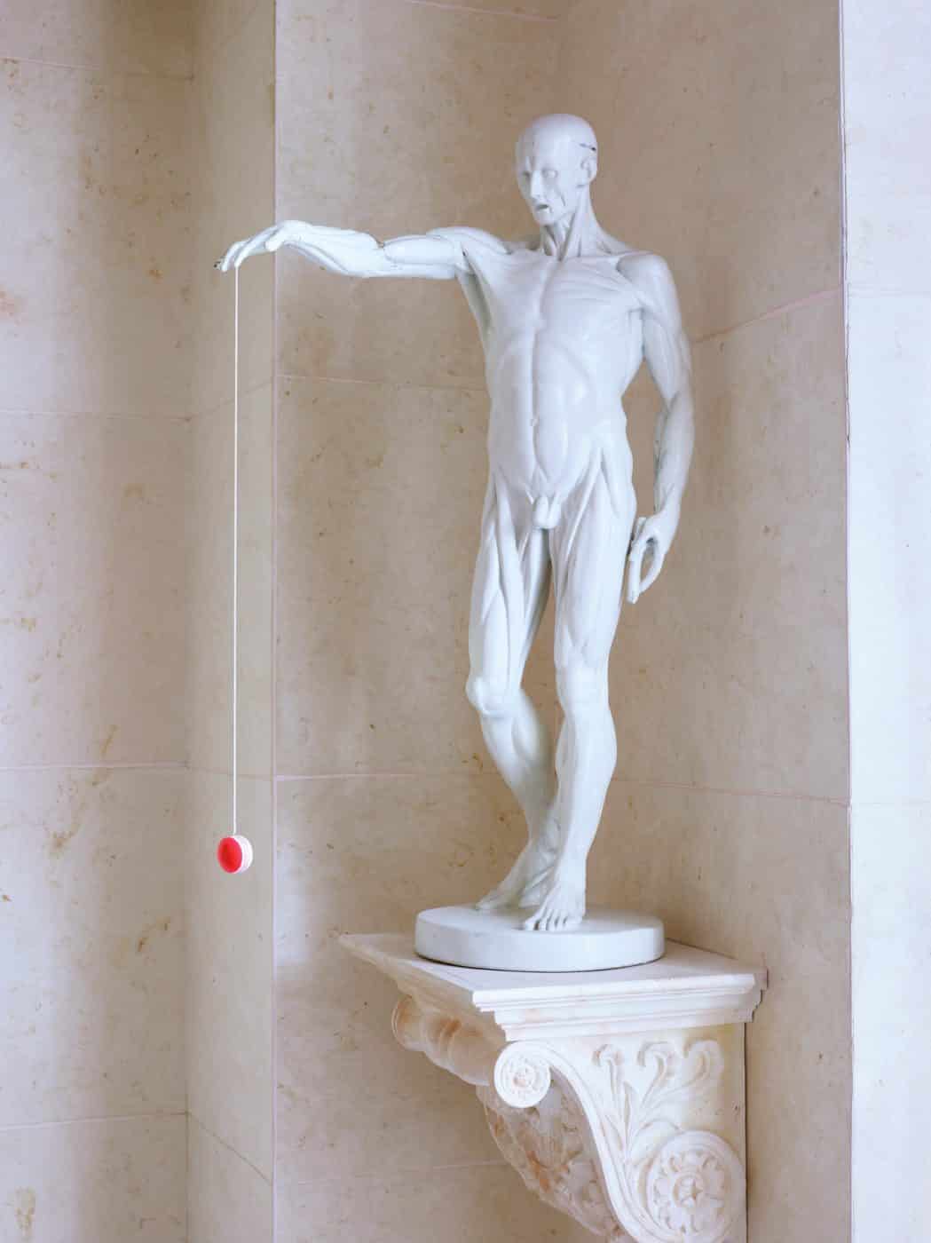A yo-yo hanging from the hand of a reproduction Jean-Antoine Houdon sculpture in Prisant's home