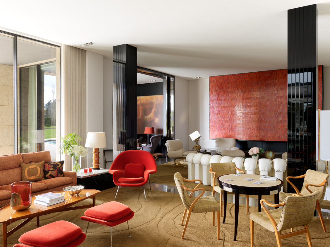 Image of the living room that includes pops of red and orange furniture