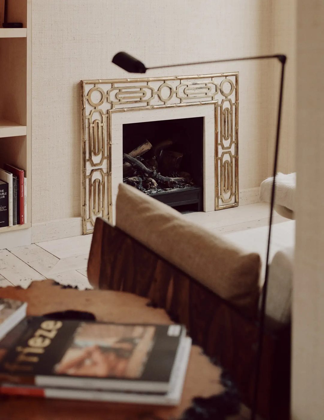 A vintage brass FIREPLACE SURROUND makes the hearth the focal point of the living room in a London PIED-À-TERRE