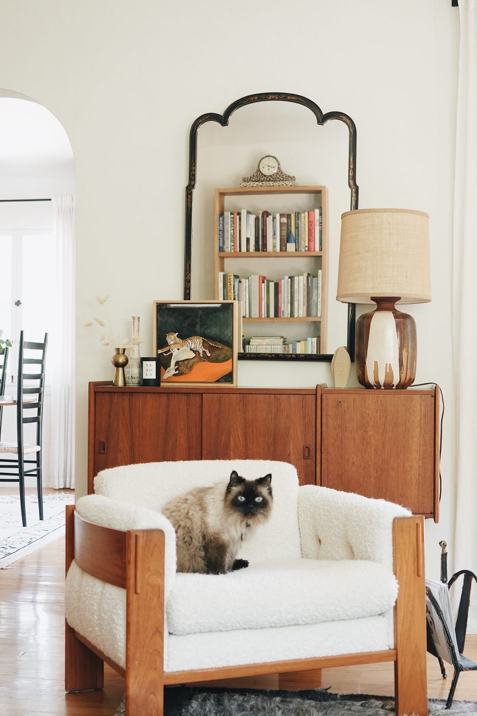 A cat sitting on a chair in a living room designed by Mulholland