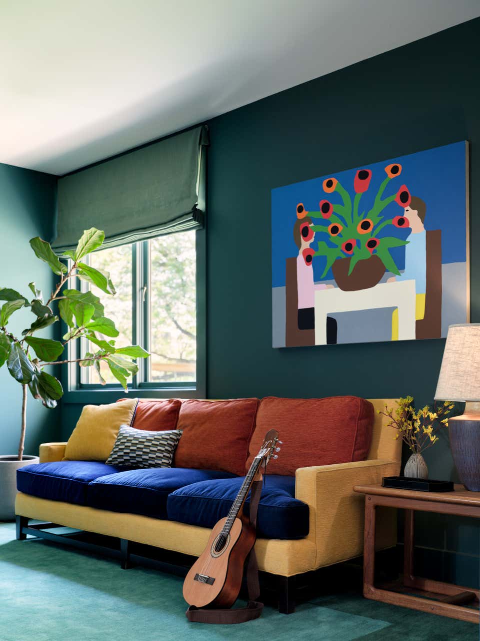 green living room with red, blue and yellow sofa by Emily Tucker
