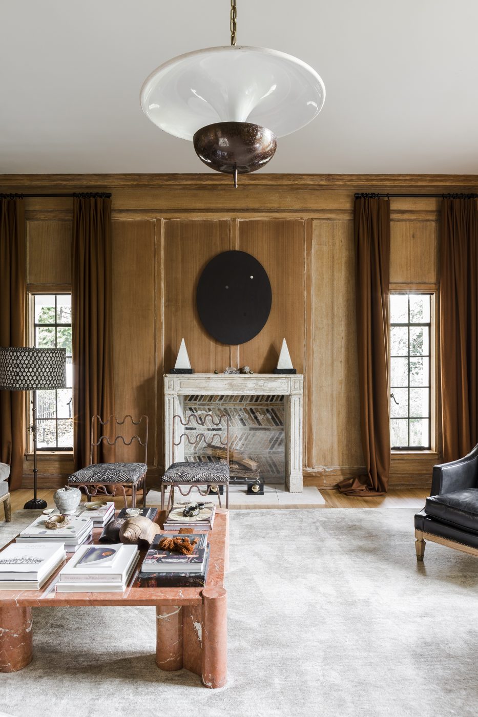 Nate Berkus's library in California, featuring a French 1950s saucer pendant in bronze