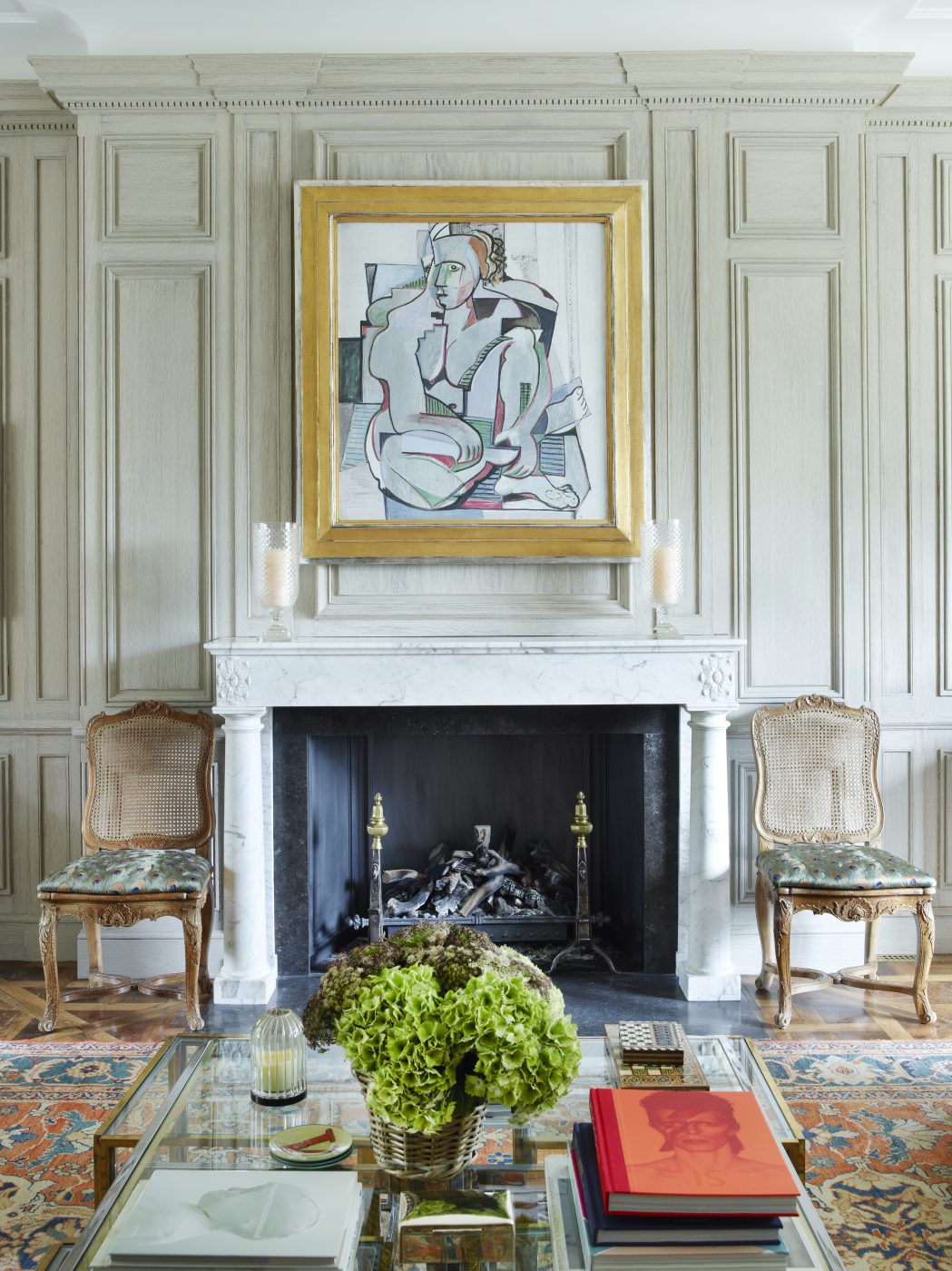 a French 19th-century Carrara marble fireplace flanked by a pair of 18th-century caned chairs