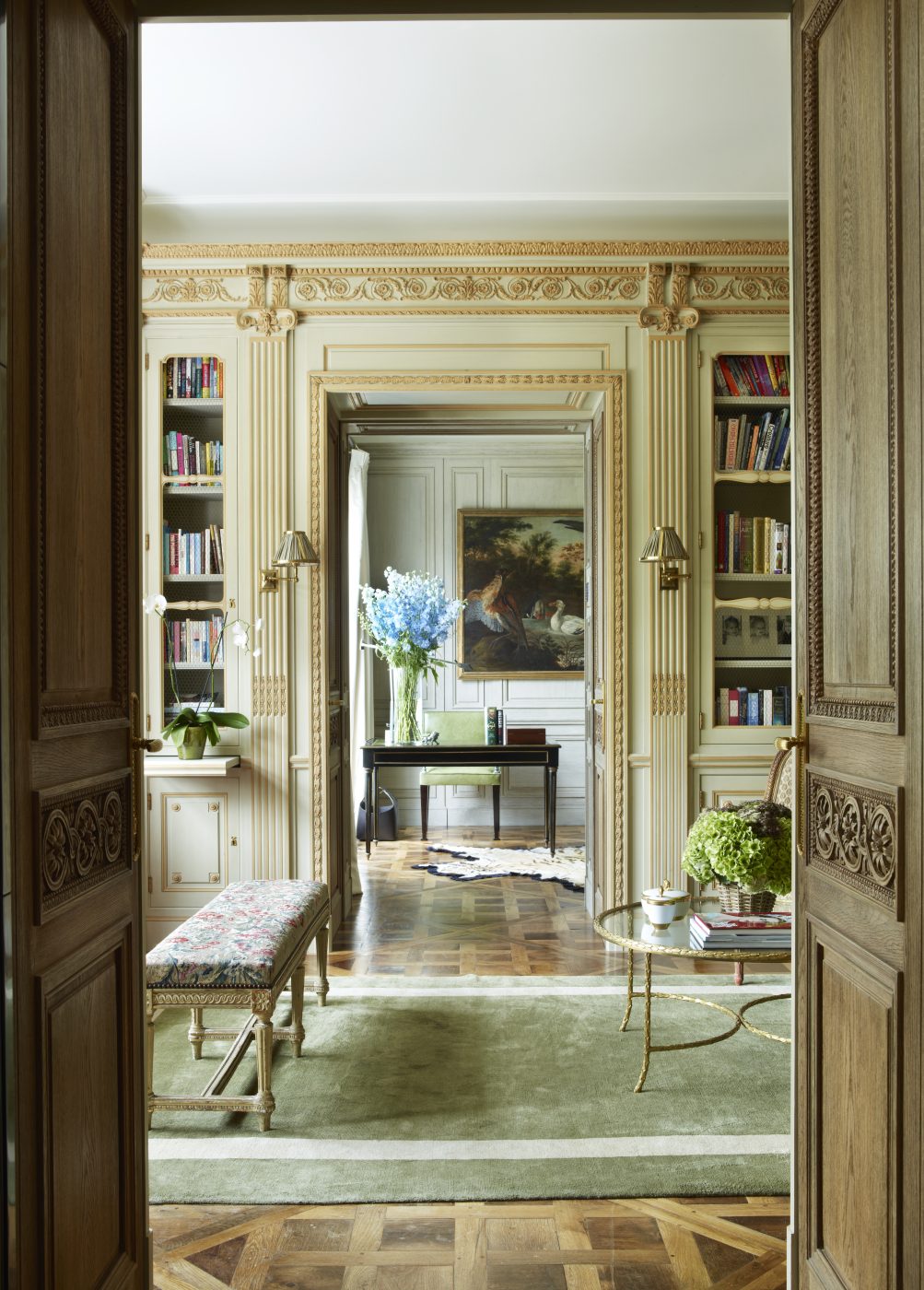 In the library, a Maison Jansen cocktail table, ca. 1950, and an 18th-century Louis XVI bench stand on a custom rug
