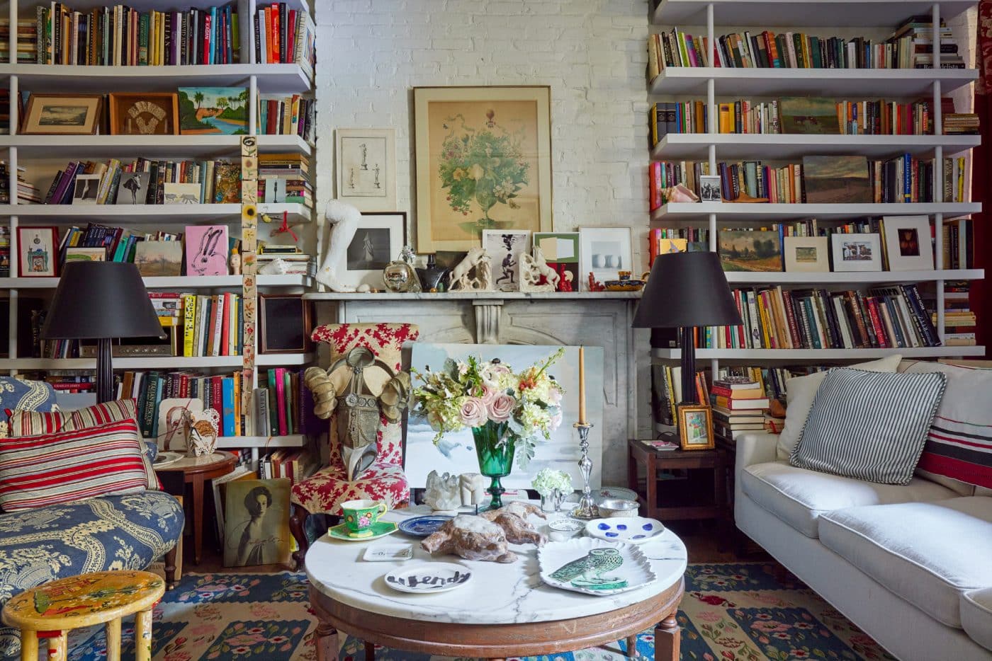 Wendy Goodman's living room with full bookshelves, matching lamps, and colorful plates