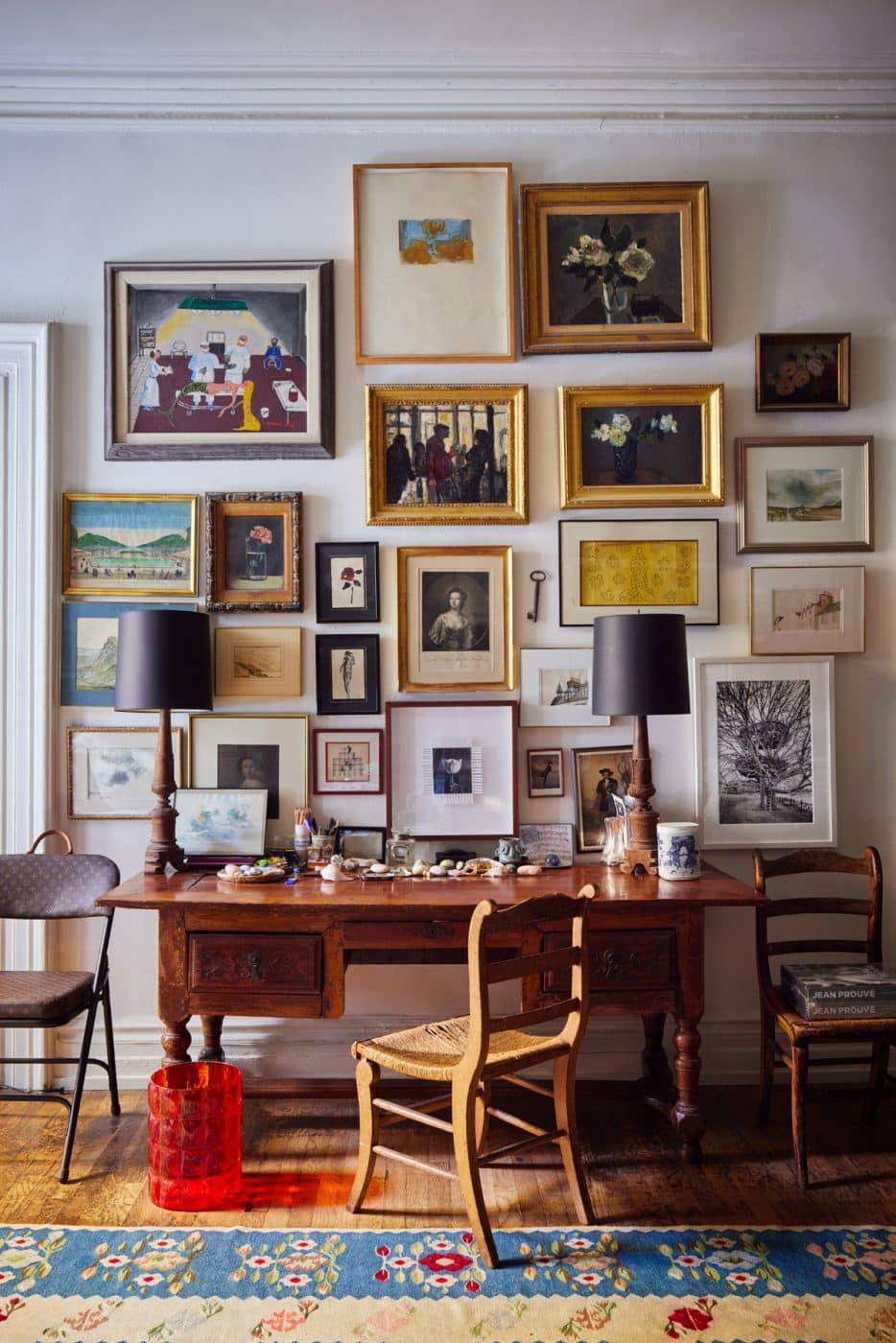 A desk area decorated with many pieces of framed art