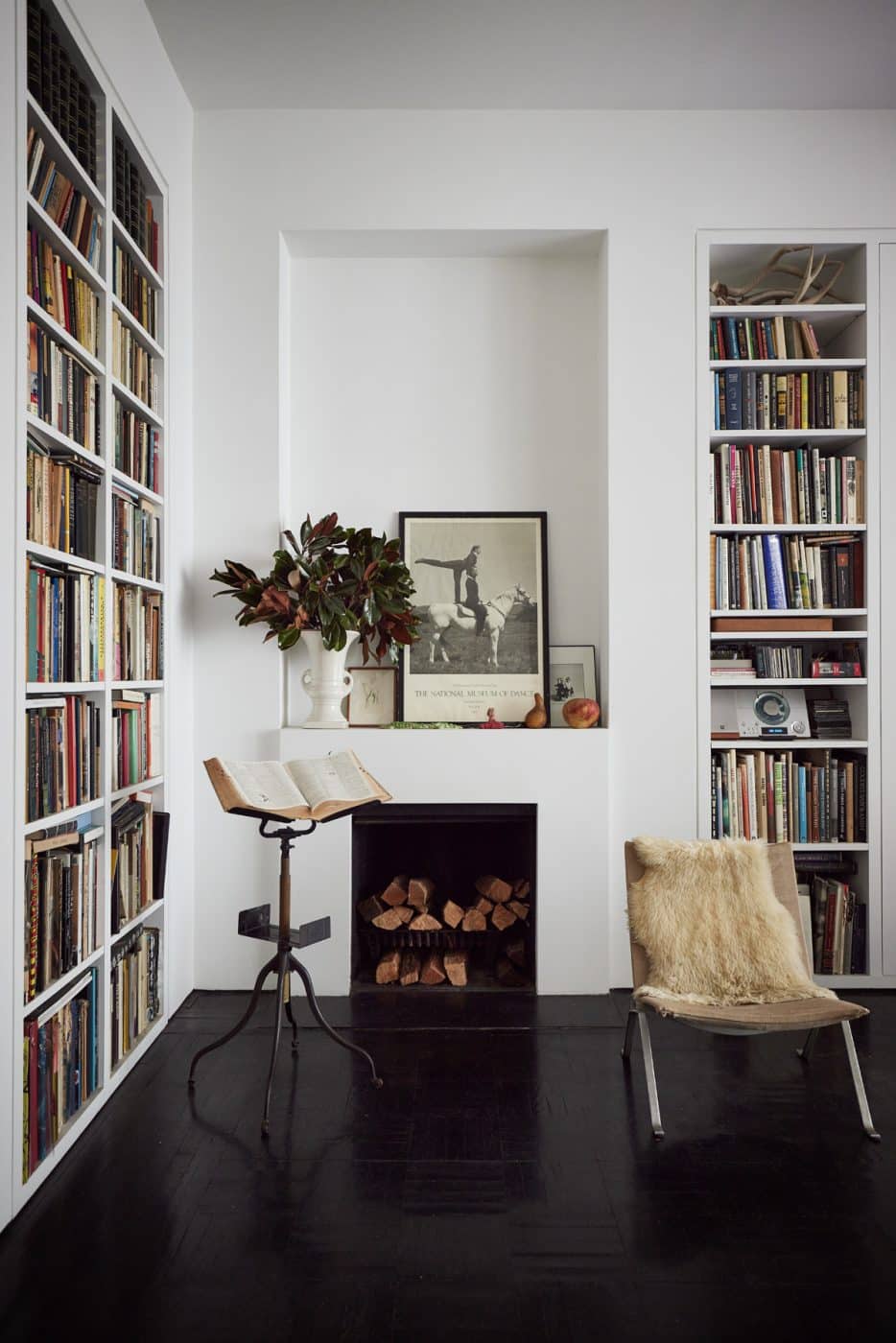 A corner of Tonne Goodman's home that features bookshelves and another fireplace
