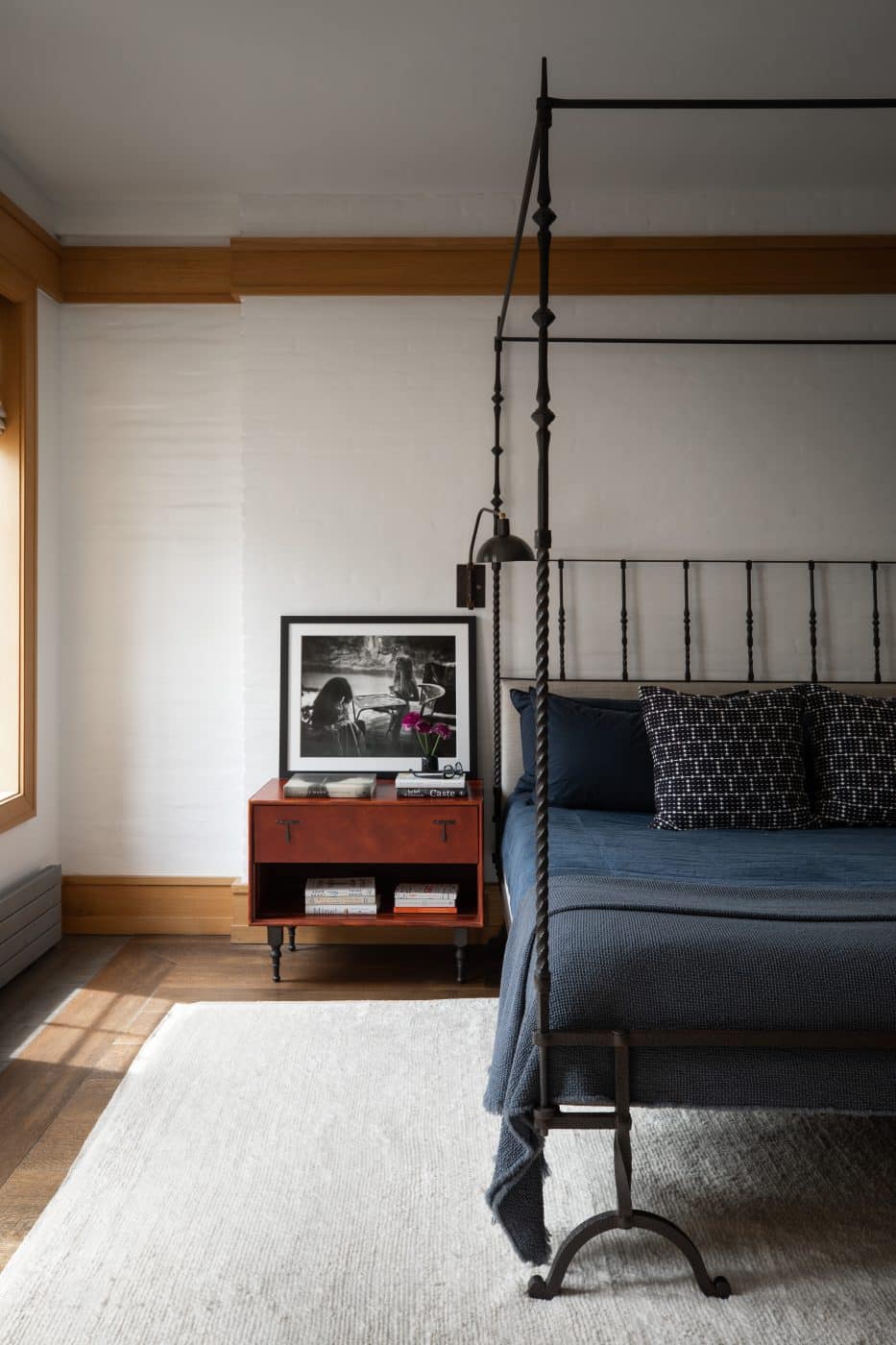 Primary bedroom designed by ASHE LEANDRO featuring an iron bed and reupholstered headboard