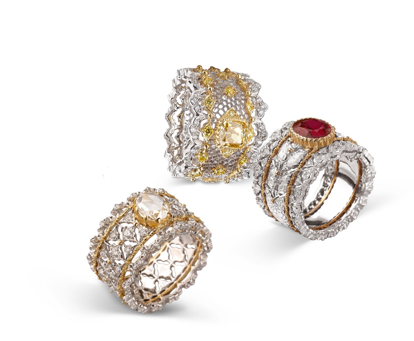 Band rings in different colors of gold set with, from left, a rose-cut white diamond, a fancy yellow diamond and a ruby.