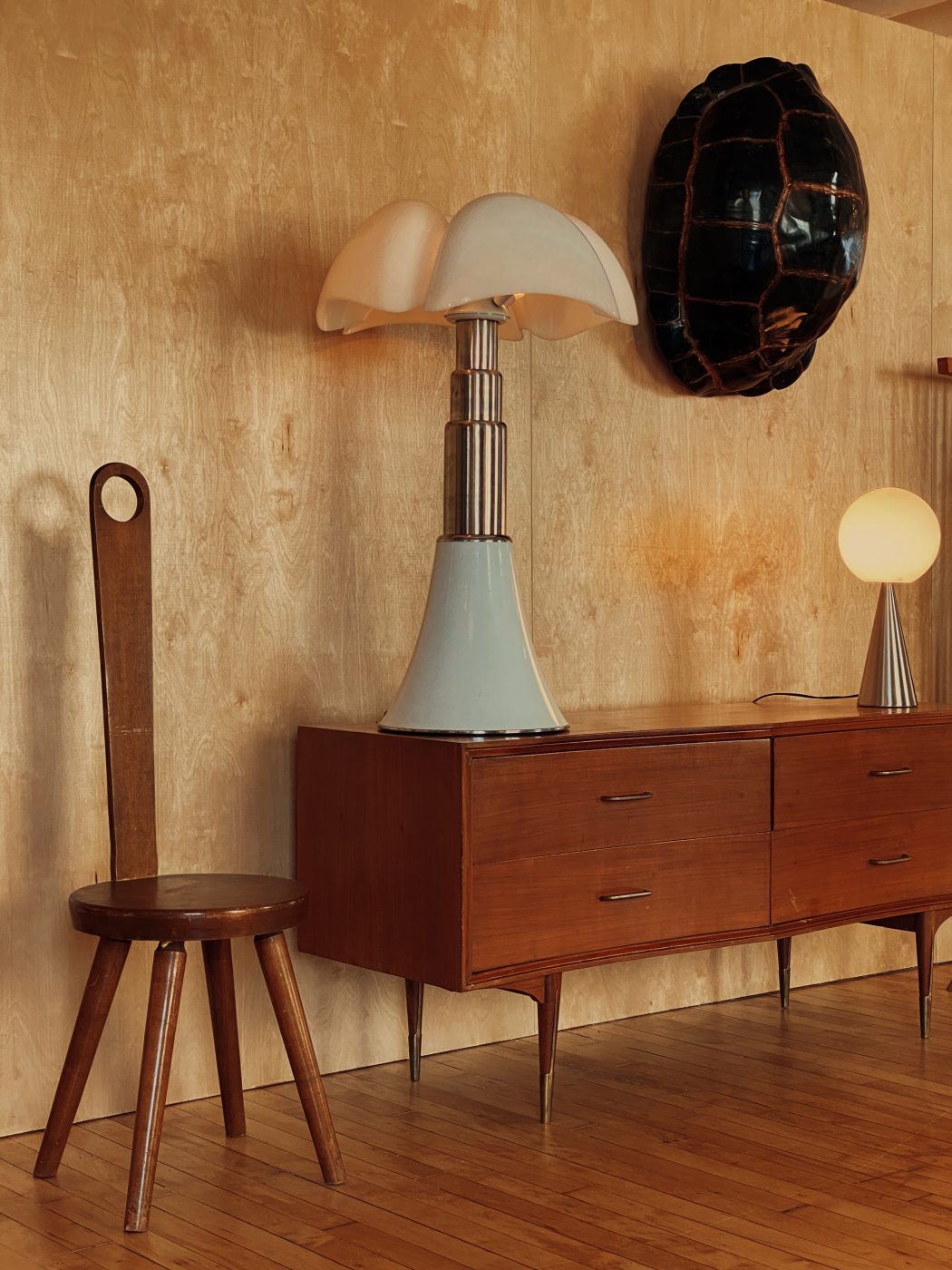 a William Fetner keyhole chair shares space with Danish sideboard and a large Gae Aulenti adjustable lamp