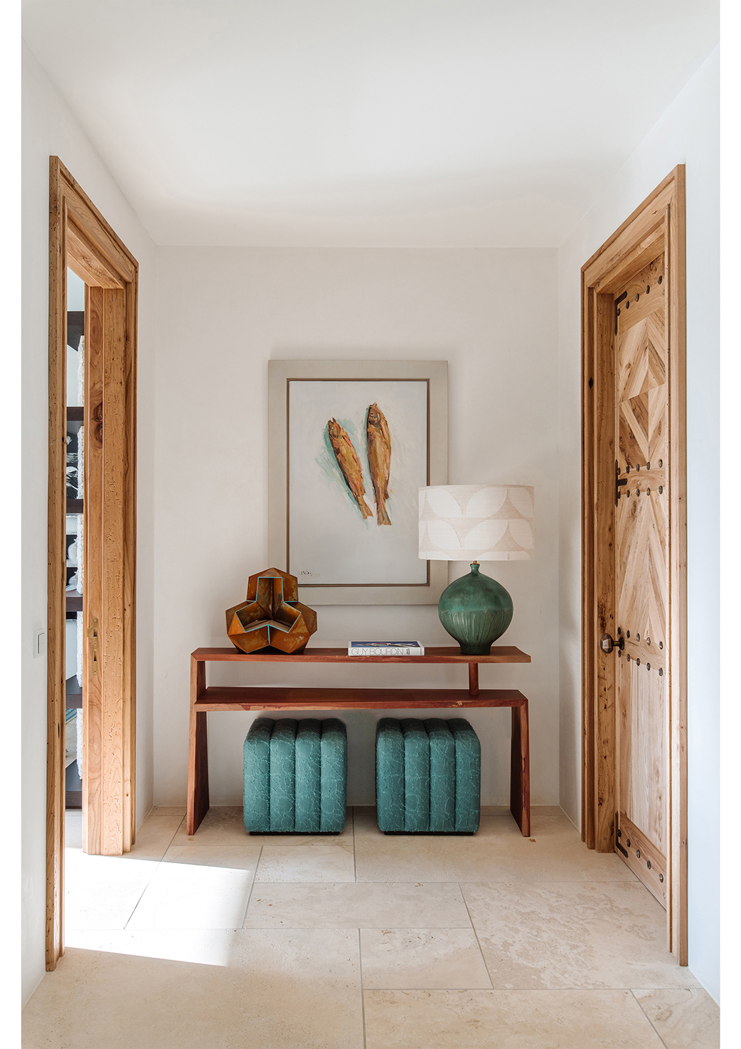 A photo of channel-tufted stools and a wooden console table in an Ibiza home, both designed by Natalia Miyar