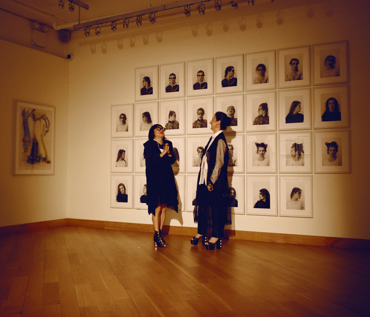 Aimée Chan-Lindquist (left), the Leslie-Lohman’s director of external affairs, and executive director Alyssa Nitchun share a moment in front of the 30-portrait installation Face Art, 1983, by Lorenza Böttner