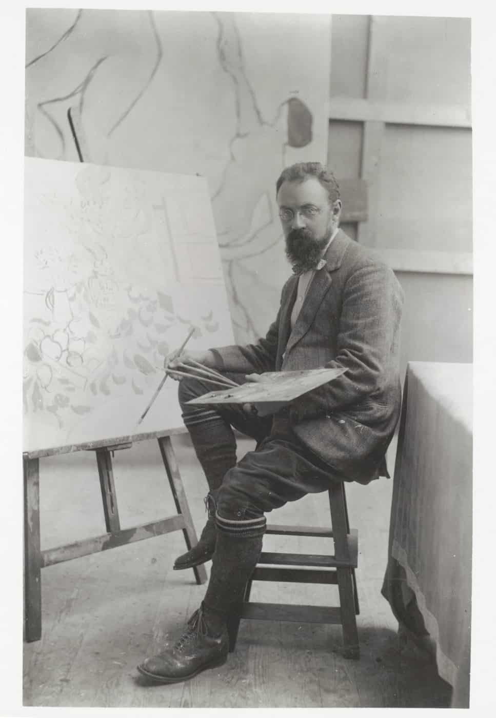 A black and white photo of Henri Matisse in his studio in 1909