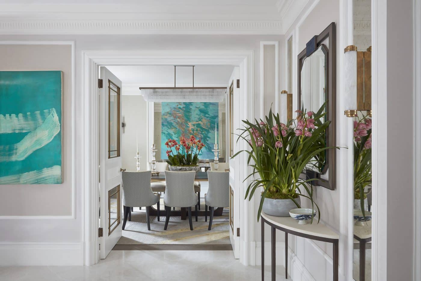 neutral entryway and dining room with teal artworks by Katharine Pooley