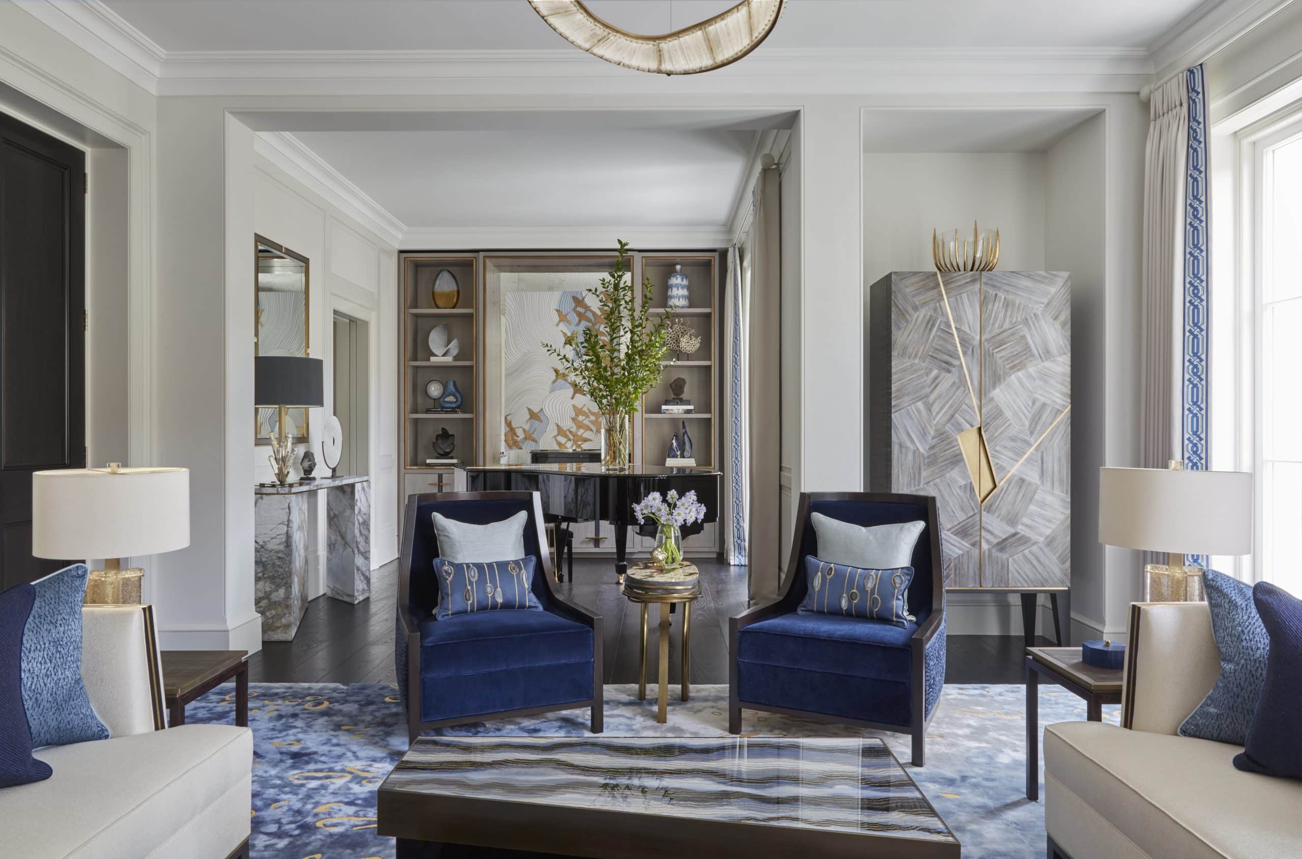 living room with blue accent chairs and area rug by Katharine Pooley