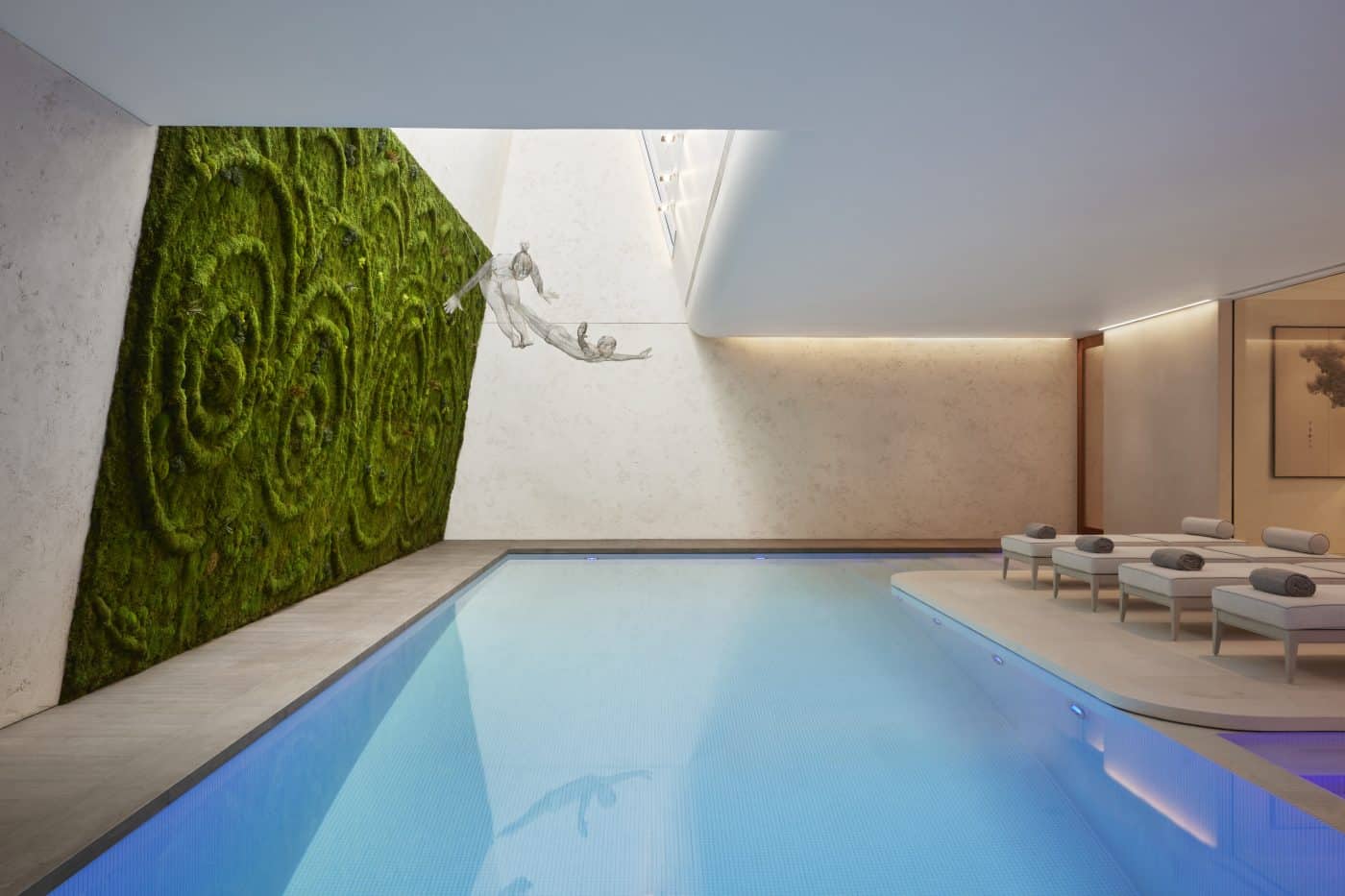 indoor pool with green wall and suspended sculptures by Katharine Pooley