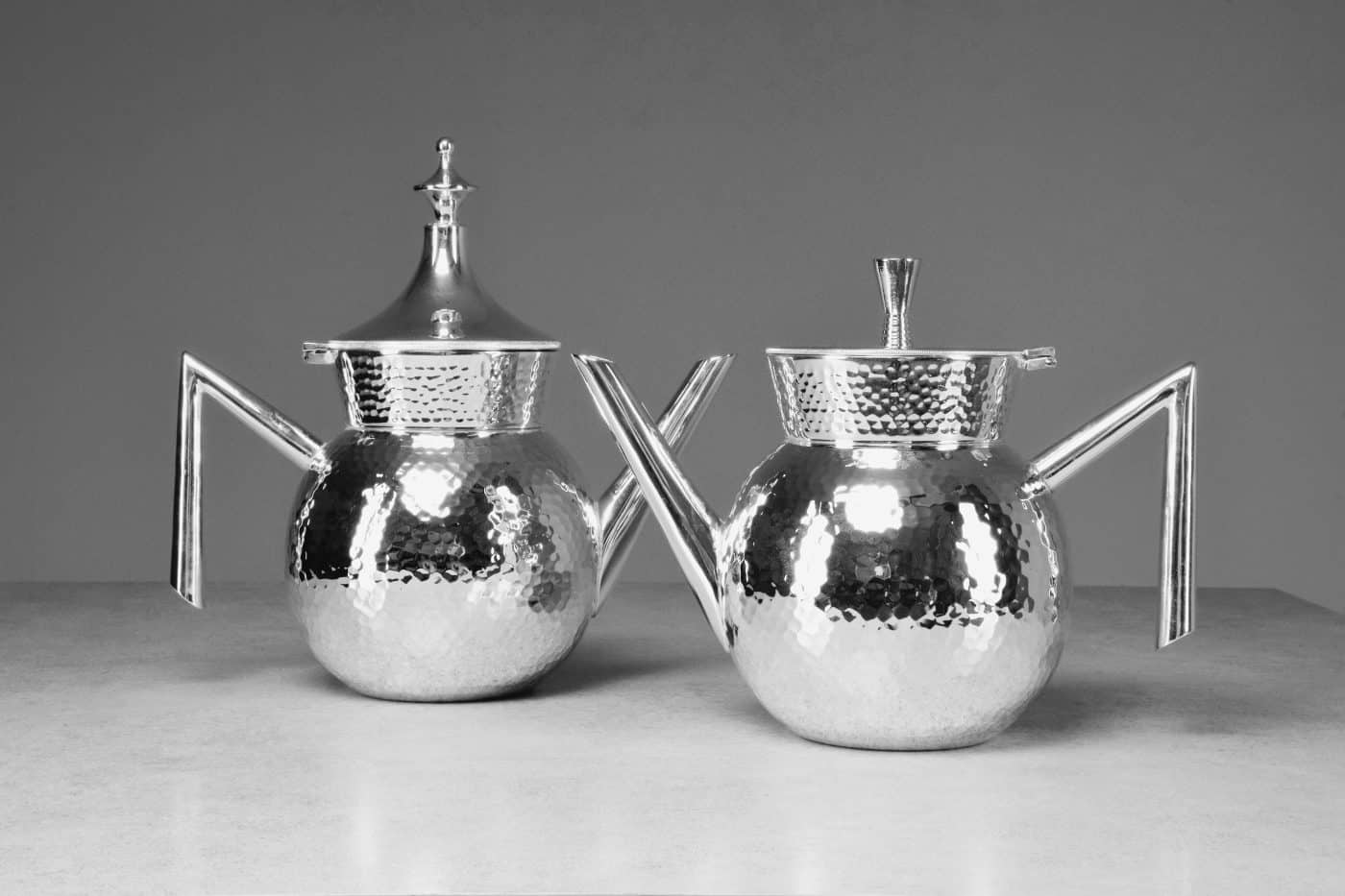 A pair of JAS nickeled-brass teapots