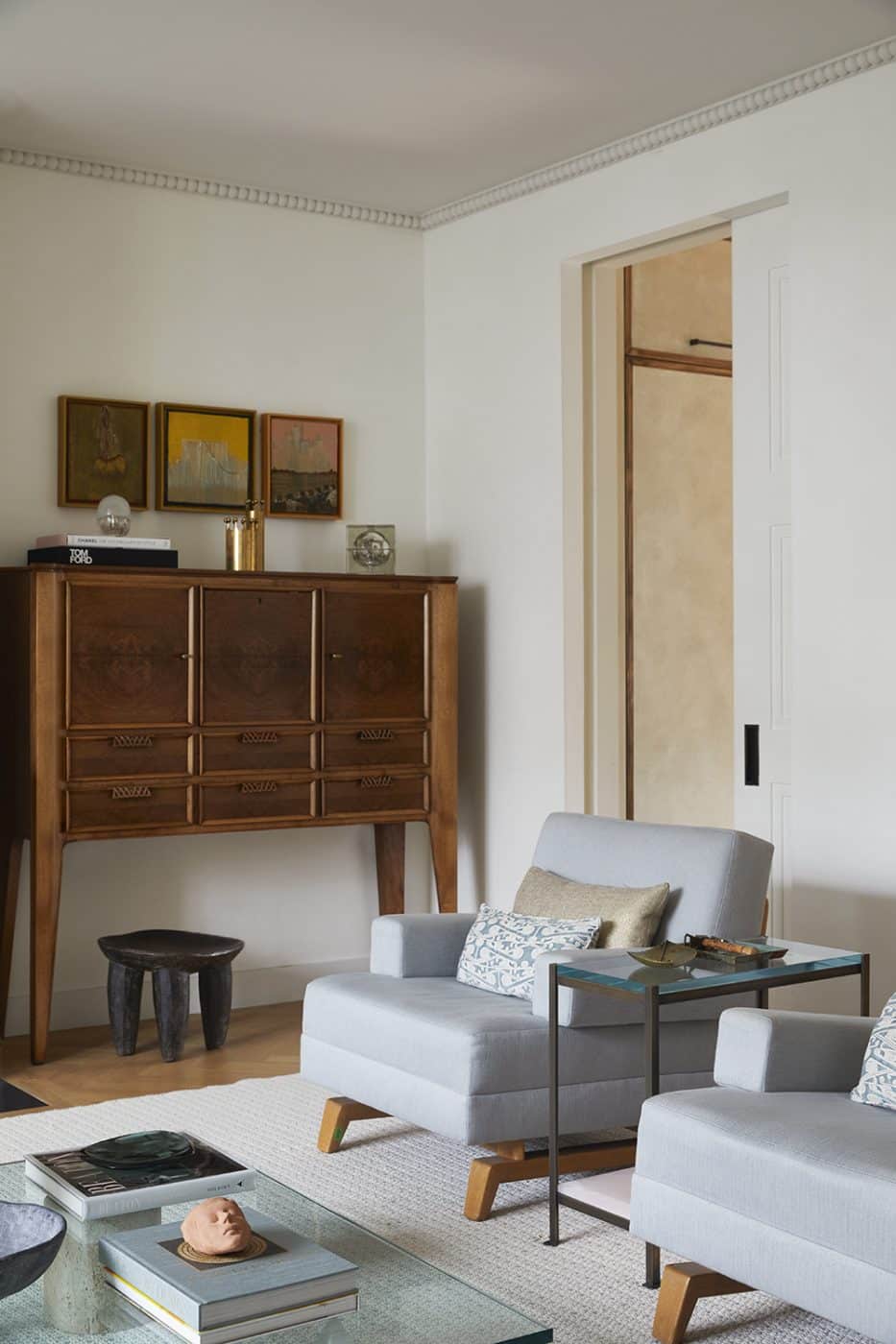 Living room of townhouse in London's Chelsea neighborhood designed by Bryan O'Sullivan featuring Paolo Buffa cabinet, carved wood Ethiopian stool