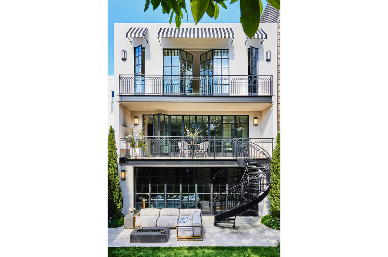 The back of a three-story Tudor Revival house with interiors by Jeff Schlarb