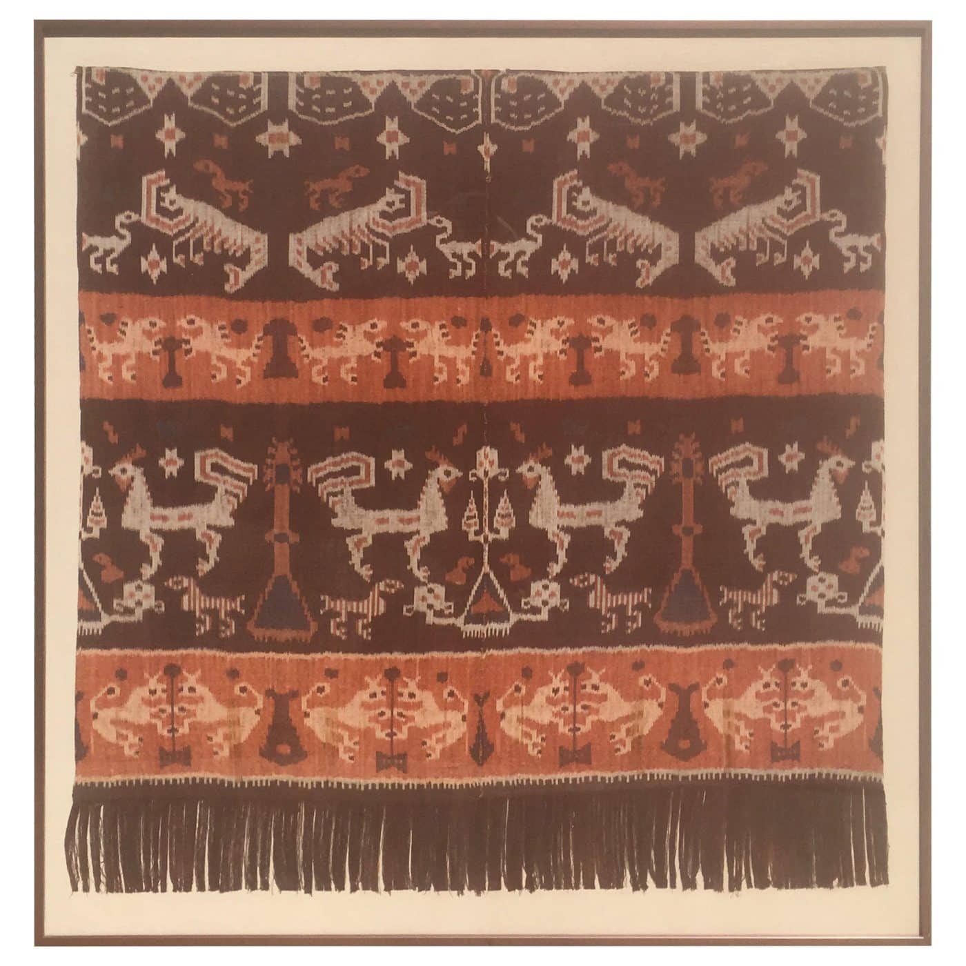A framed swath of LATE-19TH-CENTURY FABRIC, likely from Indonesia, in shades of cream, red and brick