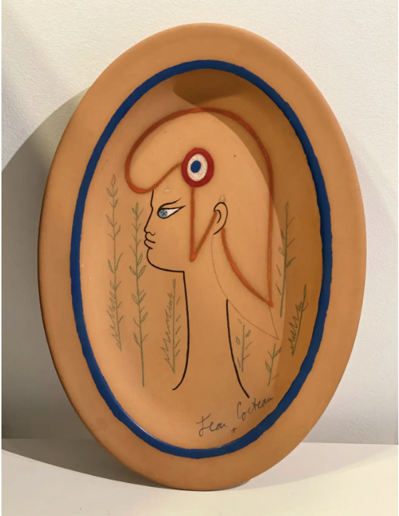 An oval plate with an illustration of the head of Marianne by Jean Cocteau
