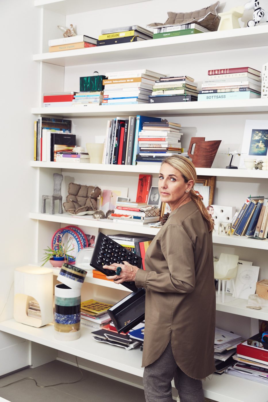 Designer Patricia Urquiola in front of a bookshelf in her studio
