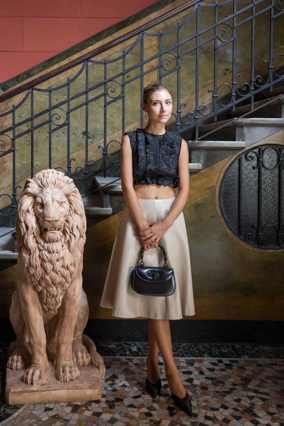 Jenny Walton next to a lion statue in the lobby of her apartment building in Milan