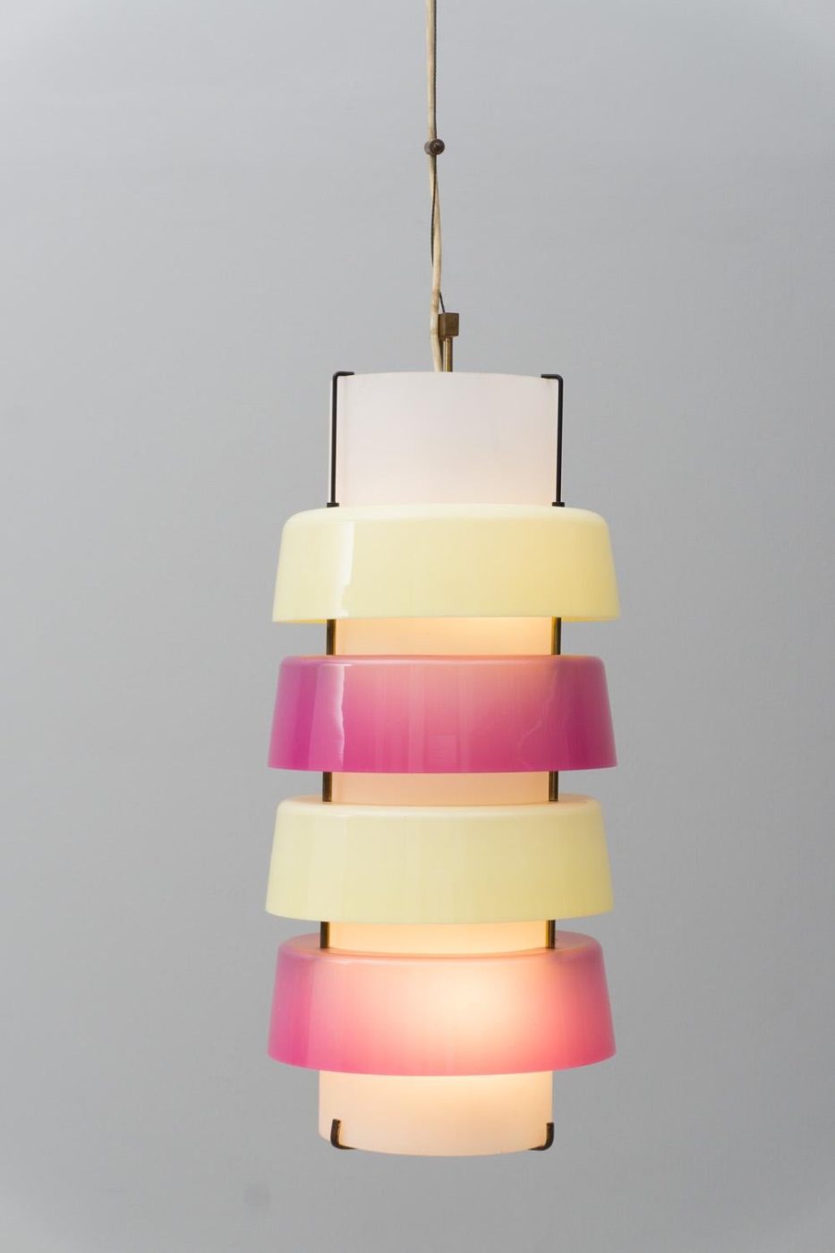 A white cylindrical pendant light with alternating pink and pale-yellow rings by Stilnovo