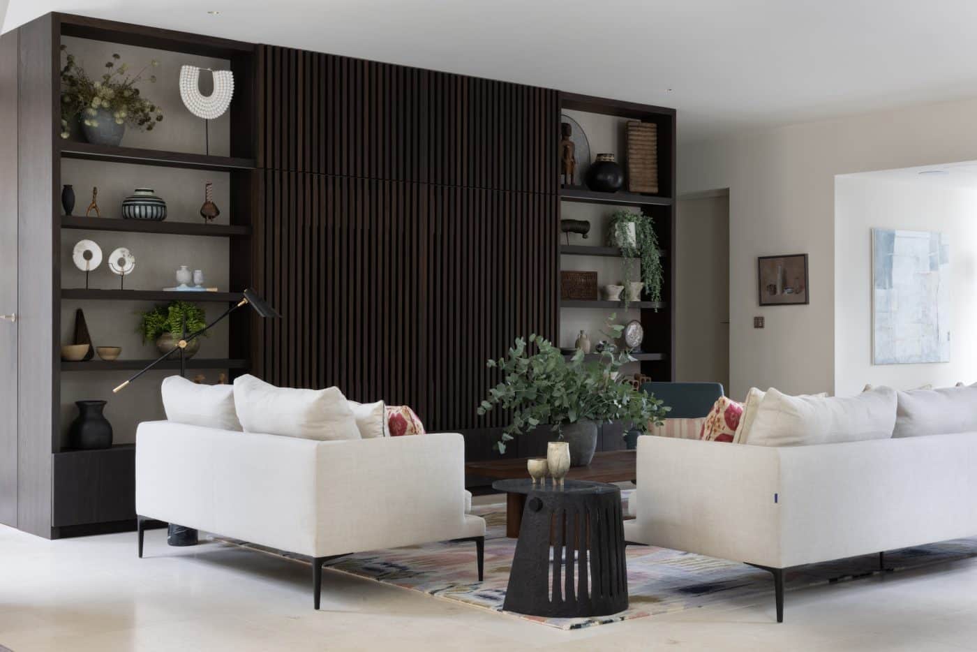 living room with dark wood paneling and white sofas