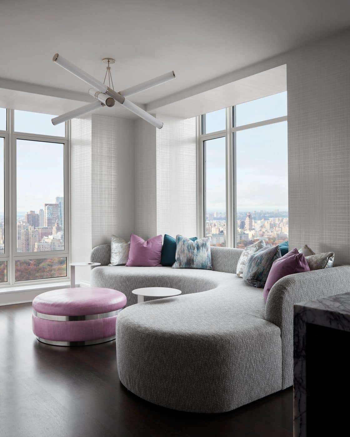 Family room with curving gray couch  in Manhattan apartment designed by Drake/Anderson's Caleb Anderson Jamie Drake 