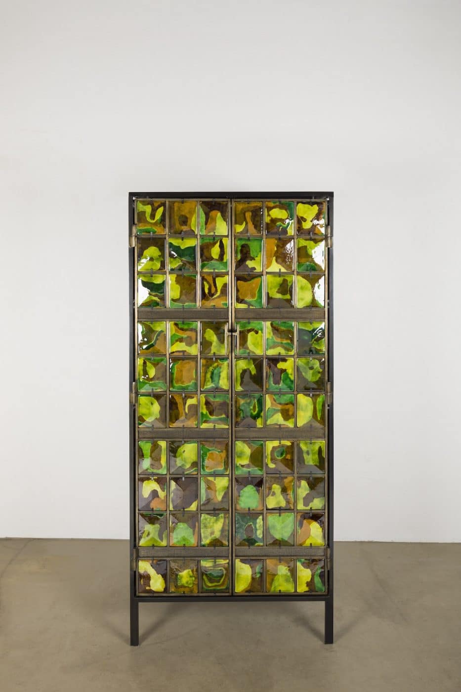 Tall cabinet by Christophe Côme with doors covered in green-and-yellow tiles.