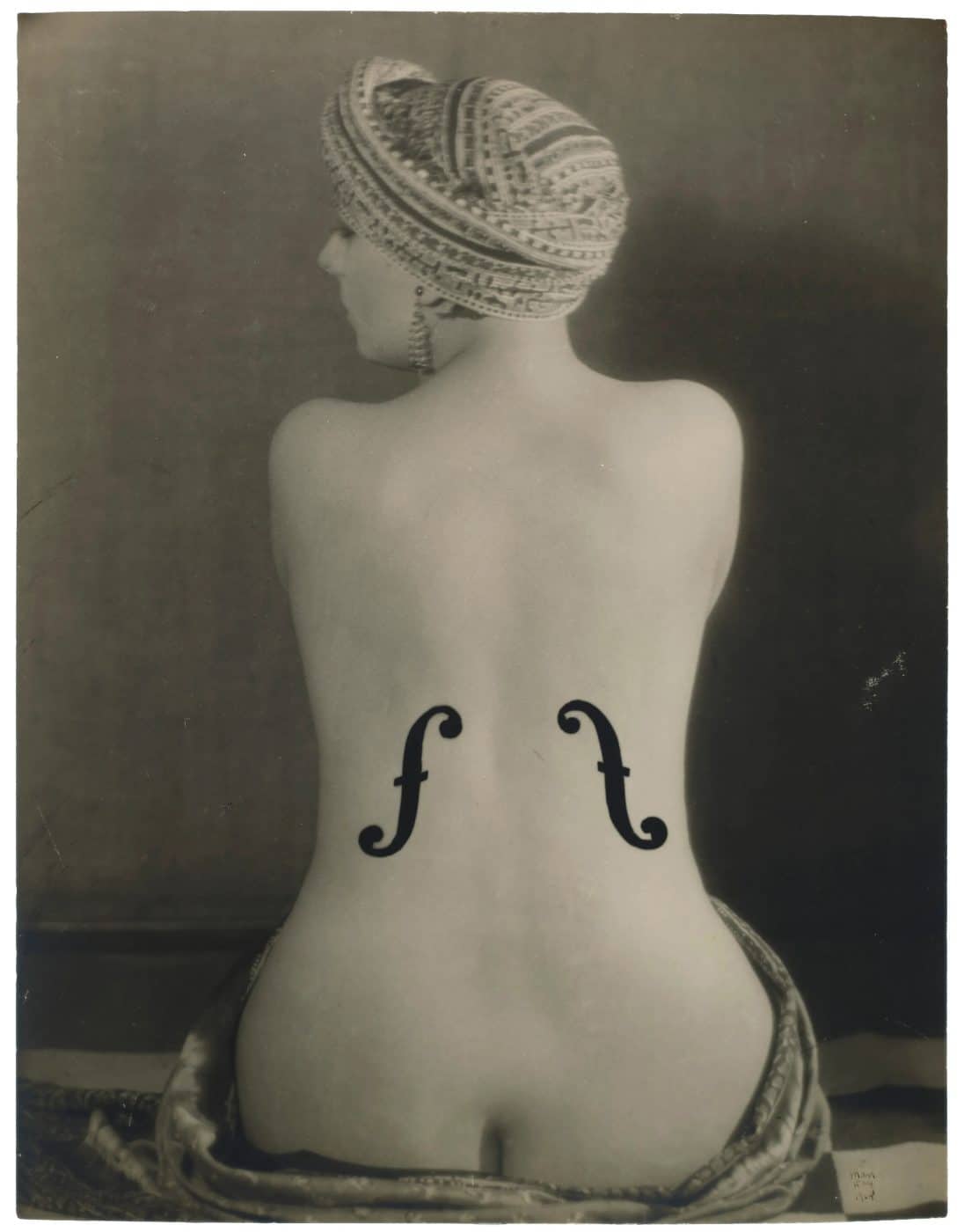 Photo of the back of a nude woman painted to look like a violin