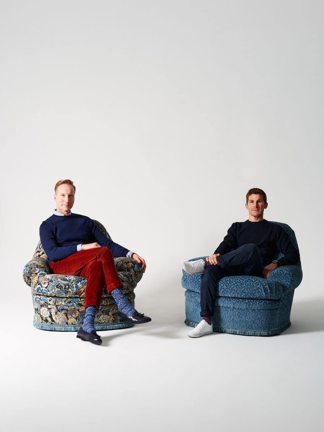 Portrait of And Design furniture company founders and designers  Martin Brudnizki and Nicholas James seated in their Wickham armchairs