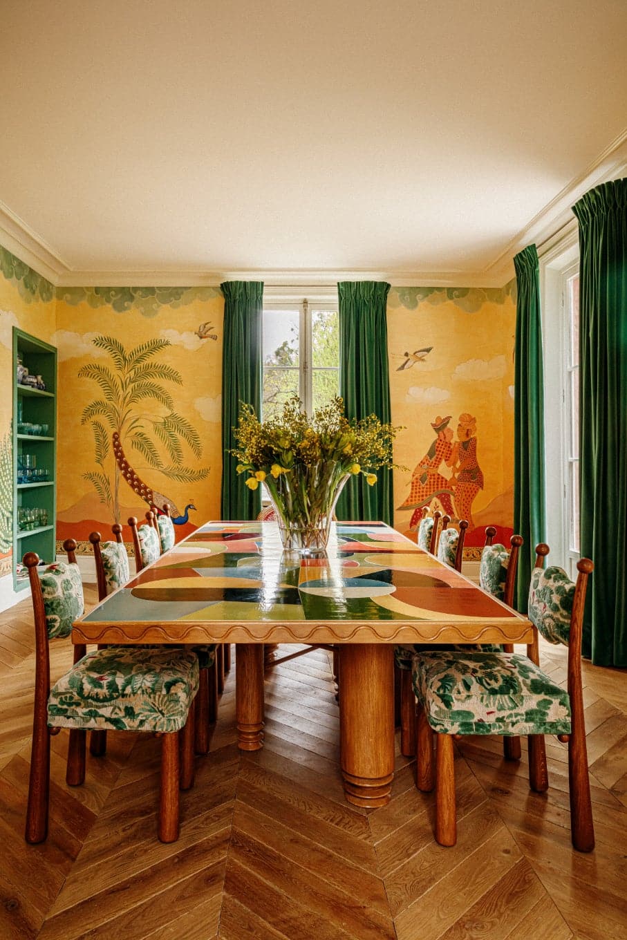 Dining room by Paris interior designer Laura Gonzalez featuring her printed Mawu chair upholstered in a verdant botanical print.