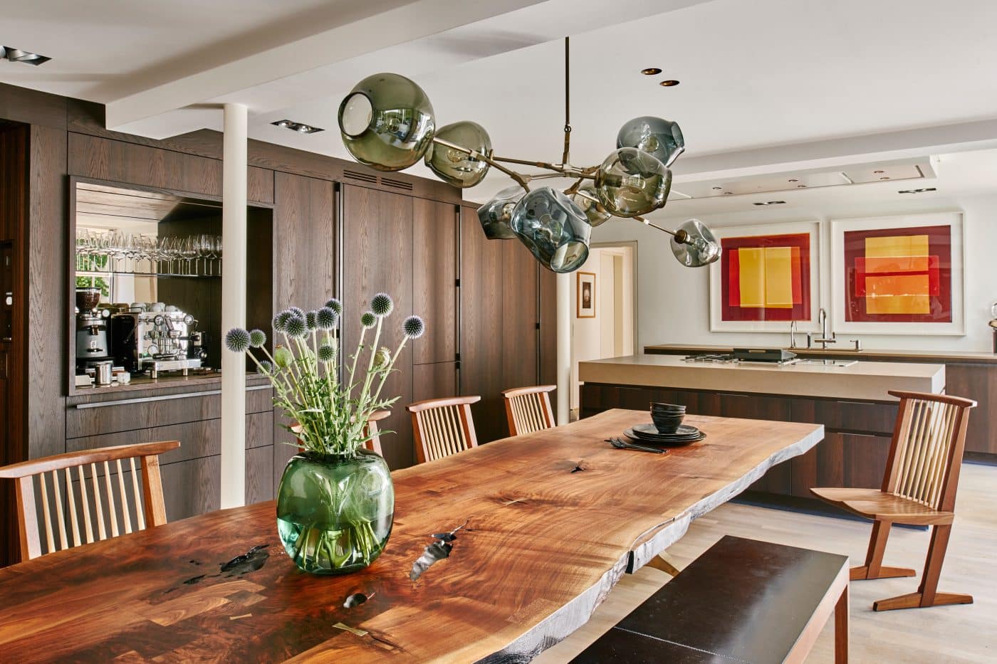 dining area in Munich home by interior designer Robert Stephan with chairs by George Nakashima at a live-edge walnut-slab plank table and bench by BDDW